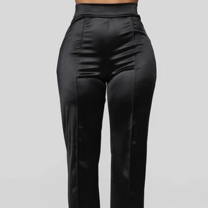 Svarta utsvängda byxor - Jättefina byxor från fashion nova som aldrig är använda. prislappen finns kvar förstås. Byxorna är i storlek S och är tyvärr alldeles för långa för mig därför säljer jag dom. de är i satin material.