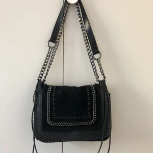 Svart mockaväska - Svart handväska i äkta mocka från Zara. Går att bära både kortare över axeln och längre över magen. Köpt för 599 kr. Endast använd ett fåtal gånger.