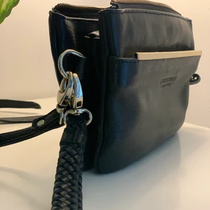 Handväska/Clutch från Stockholm  - Superfin handväska som kan hängas snett samt som clutch då rem går att koppla loss. Smart förvaring samt dragkedja på ficka fram. Mobilen och en mindre plånbok får lätt plats samt lite annat… Fint skick 👌🏼🥰  