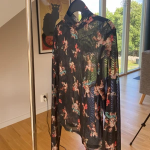 Långärmad meshtröja - Snygg långärmad meshtröja med en liten polokrage. Svart med söta änglar på. Sitter tight och lite croppad. Orginalpris 499kr 