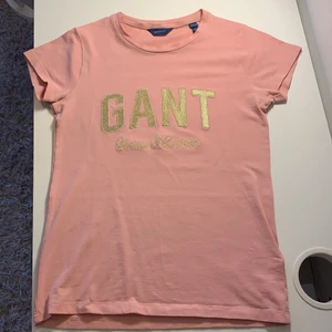 Gant t-shirt  - En jättefin gant t-shirt, inte använd så många gånger Max 10 gånger men ser ny ut. Jättefin rosa färg och guldtryck, hör av dig om du är intresserad 