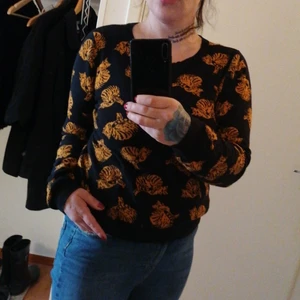 Monki tunn stickad sweatshirt  - Tunn stickad sweatshirt strl S från Monki. Nyskick. Svart med orangea katter. Mjuk, absolut inte sticksig etc. Ganska kort i modellen och passar byxor med hög midja. Figurnära. Har två likadana därför säljer jag den ena. Absolut favoritröja. 