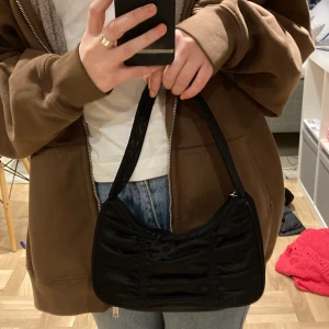 Svart axelväska från monki - Jättefin axelväska från monki med fina detaljer! Köpt för någon månad sen men använd fåtal gånger🤍 Buda från 120 kr
