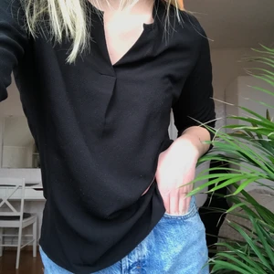 Svart blus - Simpel, svart blus som passar till det mesta, från Vero Moda. V-ringad med knappar på ärmarna. Använd ett flertal gånger. Säljer eftersom den blivit för liten.  Strl: XS   Pris: 60 kr + frakt