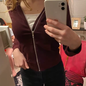 En vin röd kofta  - Säljer en vinröd kofta i stl 146-152. Den är i ett bar skick. Säljer den för att den är för liten.