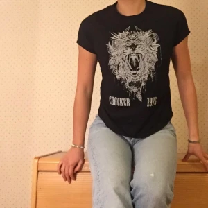 Svart T-shirt - En T-shirt med vitt tryck. Snygg passform och som kan användas till många sammanhang. 