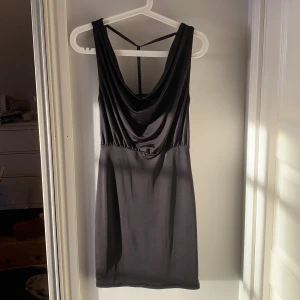 Svart klänning - Svart åtsittande klänning med silverdetalj i ryggen. Storlek XS från NLY ONE