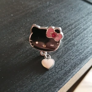 Sanrio ring - Svart med ett rosa hjärta hängande i den. Den är reglerbara. 50 kr plus 12 kr Porto. 