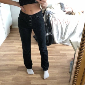 Svarta jeans med slits - Svart jeans från Nakd med slits och jättefina knappar. Storlek 36