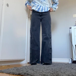 Grå loose jeans - Grå mid waist wide/straight jeans med knappar på sidorna från bikbok i storlek S. Fint skick. Jag är 165 cm. Meddela för mått/ fler bilder. Buda från 120kr eller köp direkt för 250kr. Fraktkostnad tillkommer. 