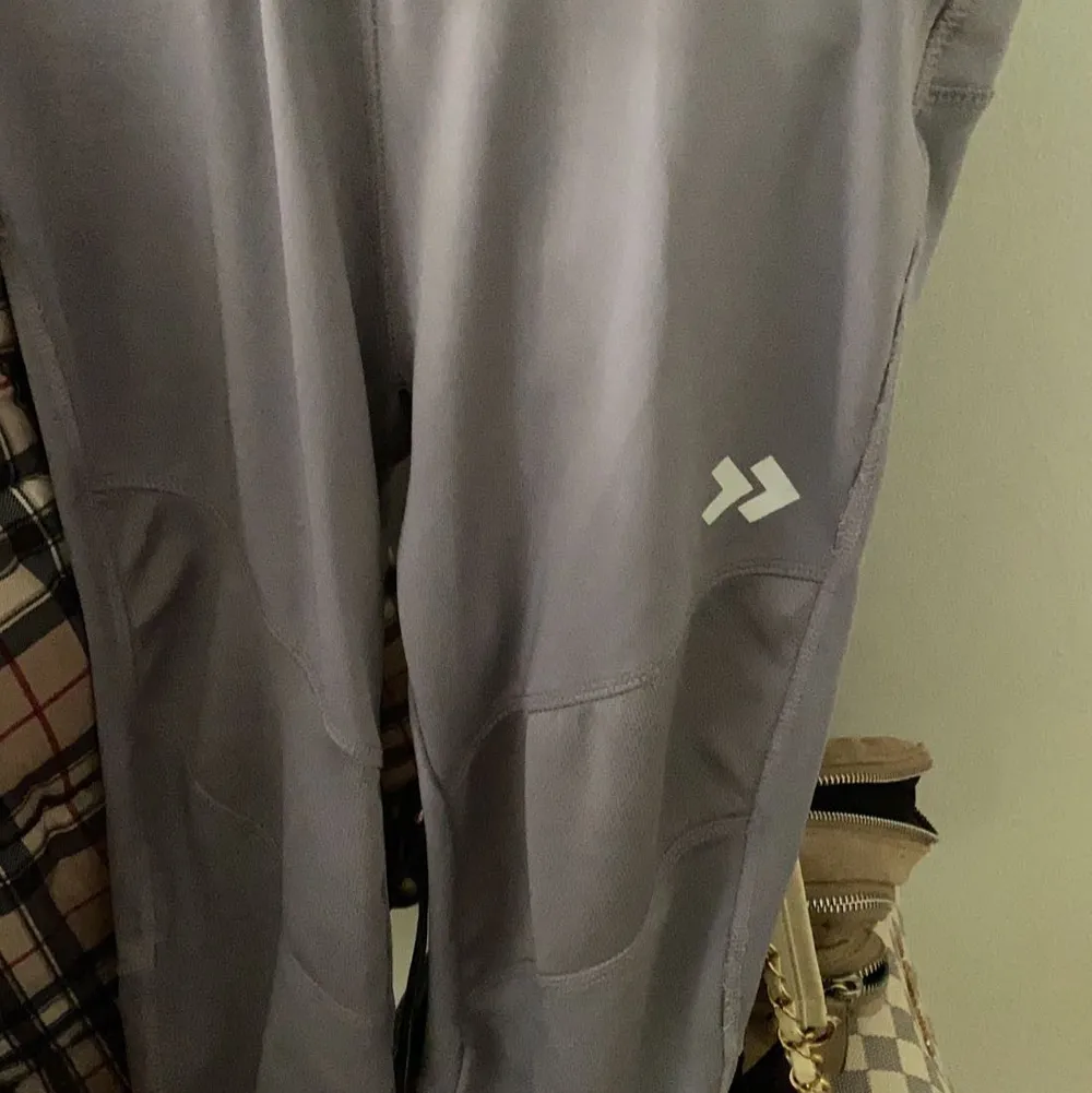 Ett par träningsbyxor i färgen grå/lila, storlek XS men passar även XXS/S . Jeans & Byxor.
