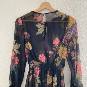 Sommar klänning  - En kort klänning med långa armar. Hela klänningen är genomskinligt eftersom kommer en svart klänning för att använda under. 