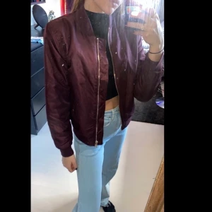 Bomberjacka storlek S  - En vinröd bomberjacka med guld detaljer, den är köpt på H&M från barnavdelningen i storleken 170, som vuxenstorlek skulle jag säga att den är i strl S. Den är i bra skick och funkar utmärkt att ha till våren. Köparen står för frakten och paketet kan spåras om de önskas. Skriv i kommentarna för frågor. :) 