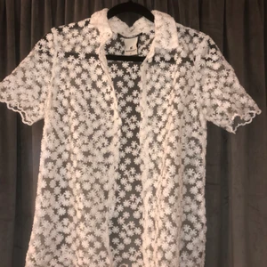 The Urban haus - En genomskinlig tröja med insydda vita blommor stl s