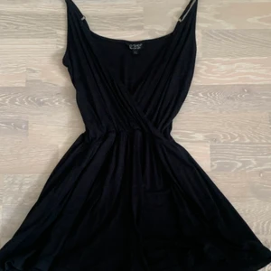 Svart kort byxdress med v-ringning från topshop i storlek 38  - Jag säljer en svart kort byxdress med v-ringning från TopShop i storlek 38, den är helt oanvänd och sitter jättebra på mig som är 165 cm lång. 