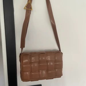 Brun väska  - Går att använda som clutch och med band. 