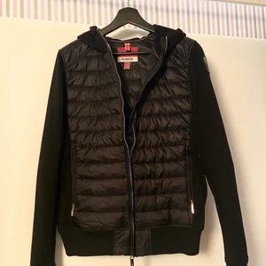 Svart Parajumpers kofta / tunn jacka i stl 16 år oanvänd  - Svarta kofta / tunn jacka från märket Parajumpers. Endast testad, aldrig använd. Lappen är borttagen men kvitto finns. Inköpt i Mars, ny för säsongen. Modellen på bilden är 162 cm lång och bär storlek 14 år, jag säljer storlek 16 år. Nypris 3199:-