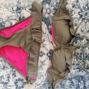 Fin militär grön bikini som är cerice rosa inuti med knytning runt halsen, från surf märket Warp helt oanvänd. 