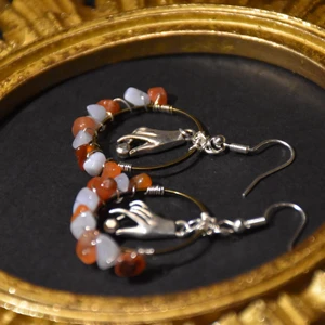 Örhängen hand  - Örhängen med handberlocker och karneol samt blå bandagat. Krokarna är nickelfria. 