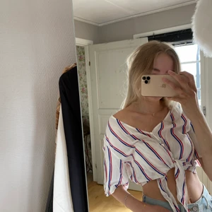 Knuten skjorta - Supersnygg, marininspererad skjorta i kortare modell med knyt-detalj. Har knappar som den stängs med. Går att styla på flera sätt! Endast en liten fläck på bröstet som knappt syns!🥰