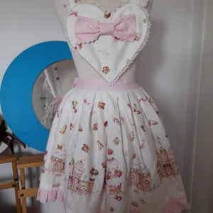 lolita klänning kjol angelic pretty - angelic pretty apron skirt. printet är country of sweets. en liten fläck som smälter in i printet och kanske går bort. även en knapp som saknas (den som connectar själva kjolen och apron) men lätt att fixa. rosett ingår! max midjemått ca 80cm