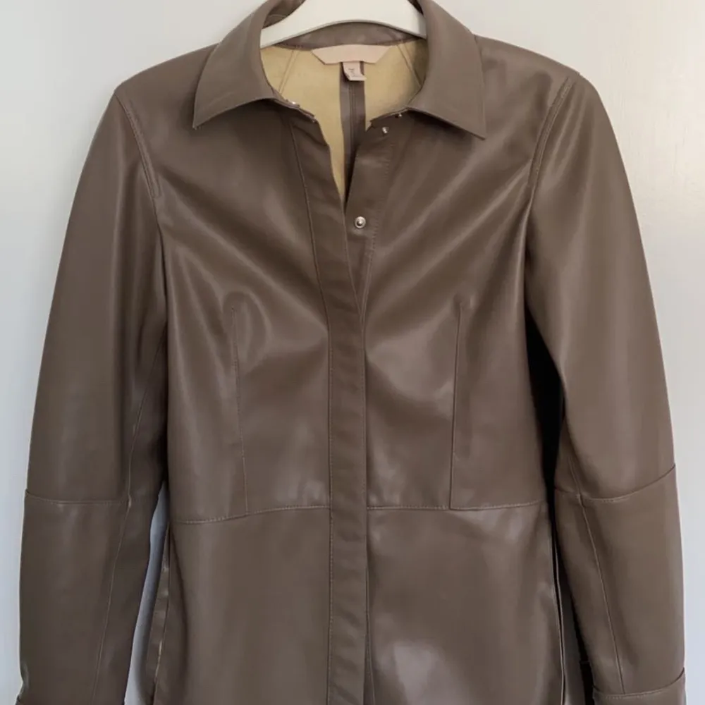En brun skinnskjorta från HM. Storlek 32 men passar lätt en  XS o S. Köpare står för frakten!!. Skjortor.