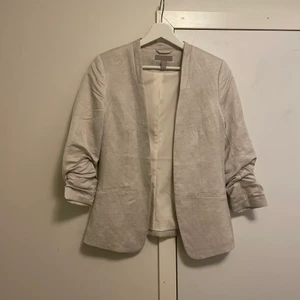 Fina kavaj från Hm i stotlek 34 - Då jag inte användt den mer än en gång på midsommar är den i fint skick. Kavajen är i linne och är beige. Står inte för postens slarv. Rök och djur fritt hem köparen står för frakten 