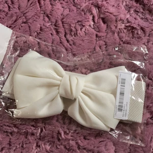 Oanvänt vitt rosettbälte - Likadant midjebälte som på bild 2. Säljes pga fick hem dubbla av misstag. Brett, stretchigt och bekvämt band med smart stängning med tryckknappar bakom rosetten. Köpt på shein. Passar nog M-XXL bäst. 💌Frakten är baserad på frimärken. Önskas postnords egna paket löser vi det.💌