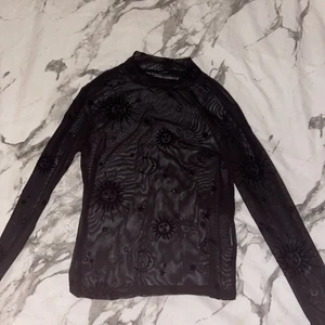 Genomskinlig tröja med detaljer - En svart genominskinlig tröja med detaljer av solar, månar och stjärnor på. Köpte på new yorker för ett tag sen men den är helt oanvänd. Storlek M men sitter lite tajtare. Köpare står för frakt!