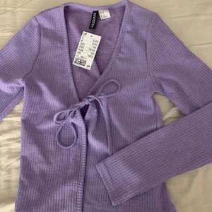 Kofta  - En lila kofta ifrån H&M. Aldrig använd lappen är kvar. Säljer pga har aldrig kommit till användning 