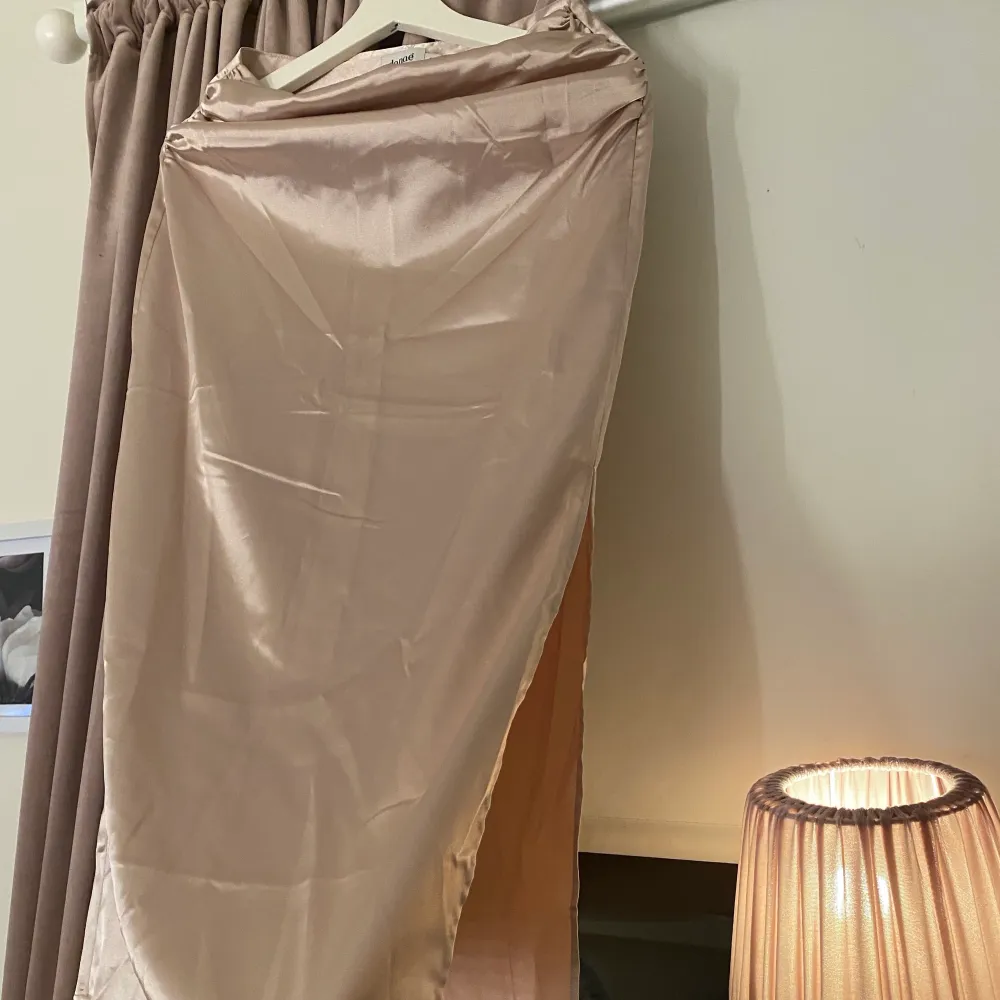 En jättefin ljusrosa kjol i silkes matrieal från NA-KD (influenser kollektion). Använt Max 2 gånger så iprincip oanvänd därav är den i väldigt bra skick. (På bilden är den bara lite skrynklig) Det är en jättefin passform på den med en slits på ena sidan. Den är i storlek S.. Kjolar.