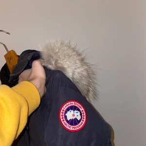 Canada gooos jacka - Hej! Jag säljer min mörk blåa Canada goose. Den är väl använd och i helt okej skick. Den är i storlek M men passar S bra! Jag har tyvärr inga kvitton osv men den är köpt i butik (johnells). Det är även äkta päls.OBS den är mörk mörk blå men ser svart ut. Pris kan diskuteras!
