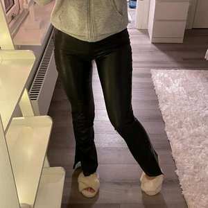 Skinnbyxor med slits från Nelly strl: S - Ett par jättefina skinnbyxor med slits på sidan i storlek S från Nelly. Säljer dessa för 250kr då de inte kommit till användning och är i fint skick. Ordinarie pris: 499kr. Frakt ingår inte i priset. 