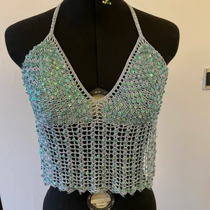 Fest eller sommar linne med glitter  - Detta är ett knyt-Linne som passar i storleken XS till M, det är virkat med ett blått garn med paljetter på framsidan. Väldigt bekvämt och snyggt att ha på sommaren. Själv hittade jag det i Frankrike i en butik. 