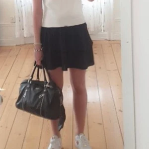 Svart volangkjol - Säljer en svart oanvänd volangkjol från Nelly i strl S. Passar bra nu till nyår med en glittrig topp eller till sommaren! Felfri och knappt använd. resår i midjan