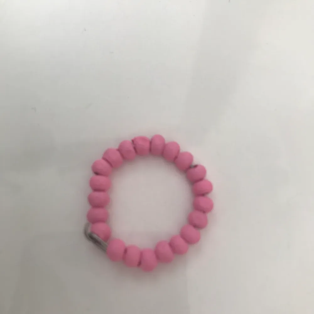 Ringen är gjord av ståltråd och har rosa pärlor🌸.            Ringen är stängd men passar nästan till alla fingrar! . Övrigt.