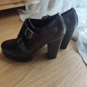 Lackade klackskor med spännen - Thriftade, rödbruna klackskor med spännen i metall! De är i storlek 38, fint men använt skick. Köpare står för frakt! Går absolut att förhandla om pris✨