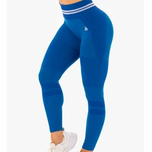 Blå Ryderwear träningstights Seamless - Blå Ryderwear träningstights  Namn: The free Seamless high waist leggings Väldigt bra skick. Endast använd två gånger Storlek Small S Nypris är ca 749 kr Samfraktar  Detta är hemsidans förklaring:  The Freestyle Seamless High Waist Leggings have been perfected for optimal movement, constructed from our unrivalled seamless knit technology for that near naked feel. Whether you’re lounging or lunging, these leggings offer ultimate comfort with a fun, fashionable, body contoured style. The distinctive love heart booty and ribbed contouring flatter your figure, flaunting your glutes and waist. The seamless fabric provides maximum range of motion and agility for dynamic, high-octane home workouts. These luxe leggings also feature a stylish, woven athletic double stripe and can be paired perfectly with the Freestyle Longline Sports Bra.  -High waisted legging  -Full length  -Seamless knit technology  -Smooth second skin fit  -Supportive seamless rib waistband  -Flexibility for maximum movement  -Lightweight  -Woven Ryderwear logo  Recommended for lifestyle, home workouts and gym training.  Due to the nature of the soft, seamless fabric we recommend to always wear similar skin tone seamless G-Strings under your seamless leggings and shorts.  Model is 167cm tall, she usually wears a size Small and is wearing a size Small. Her waist measures 69cm and her hips measure 84cm.  63% Nylon/24% Polyester/13% Spandex