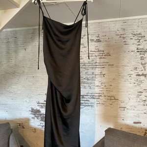 Svart sidenklänning  - Säljer denna fina svarta sidenklänningen från Hanna schönbergs kollektion för NAKD pågrund av ingen användning. Använd en gång, köpt förra hösten och går ner till början av knät på mig som är 172cm. Klänningen går även in lite i midjan. Ordinariepris var 449kr och säljs nu för 300kr inklusive frakt och är i väldigt fint skick!