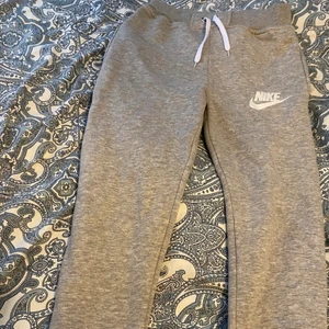 Gråa Nike mjukisbyxor - Gråa Nike sweatpants med vita snören. Storlek: S/M    Jag är cirka 165cm lång och dem passar bra