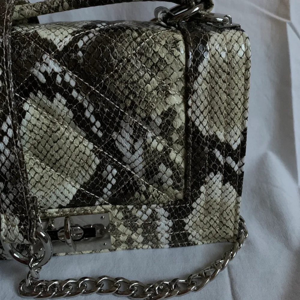 Handväska från Gina Tricot i snakeprint. Oanvänd men tyvärr utan prislapp! . Väskor.