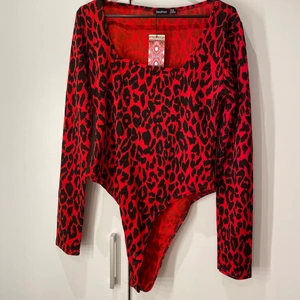 Röd body med leopard tryck - Fin body ifrån boohoo, med leopard mönster. Storlek L men skulle säga att den är liten i storleken speciellt om man är lång, då den inte räckte till för mig på längden. Helt ny och aldrig använd! Skriv gärna om ni är intresserade eller har frågor/ vill se mera bilder på plaget, ex hur det sitter på osv❤️ pris kan diskuteras!