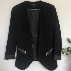 Svart kavaj - Snygg figursydd svart kavaj ifrån H&M i storlek 40. Dragkedjor men utan fickor och små axelvaddar. 
