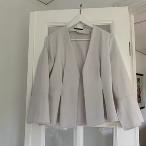 Grå kavaj  - En grå kavaj som har en snygg slits där bak för att forma kroppens kurvor.