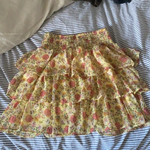 Blommig volangkjol - Blommig volangkjol med resår band i midjan som gör den stretchig mellan storlekarna! Funkar mellan S och L, från Lindex