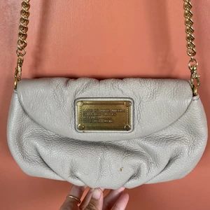 Fin Marc Jacobs väska - Fin väska från Marc by Marc Jacobs i ljusbeige läder och avtagbar guldkedja. Remmen är original från Marc Jacobs men från annan väska. Den kan tas bort och väskan kan användas som plånbok/clutch.  Finns två små fläckar men den är i bra skick! Nypris: 1800. Köparen står för frakten. 