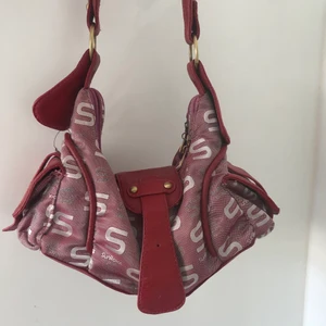 Röd handväska - Så snygg handväska köpt i secondhand. I begagnat skick men fortfarande väldigt fin. Knappen på ”flärpen” har gott av och är utbytt med en magnetisk knapp istället. 