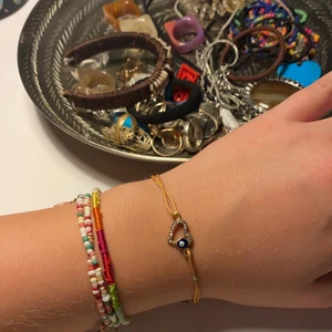 Jättegulligt armband köpt i Grekland!! - Jättefint armband, med ett hjärta med strass och ett litet lyckoöga i! Frakt ingår ej! <3