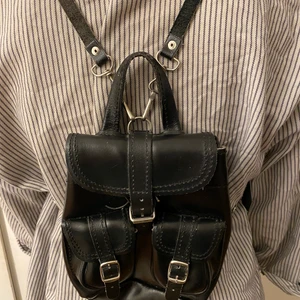 Svart Liten skinnväska  - Svart skinnvästs med silvriga detaljer bra skick!