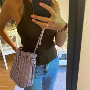 Lila väska - Lila väska från zara. Har ett långt band som går att ta av och även korta band. Kan knytas runt där uppe efter hur man vill ha den. Använd 1-2 gånger, bra skick. 